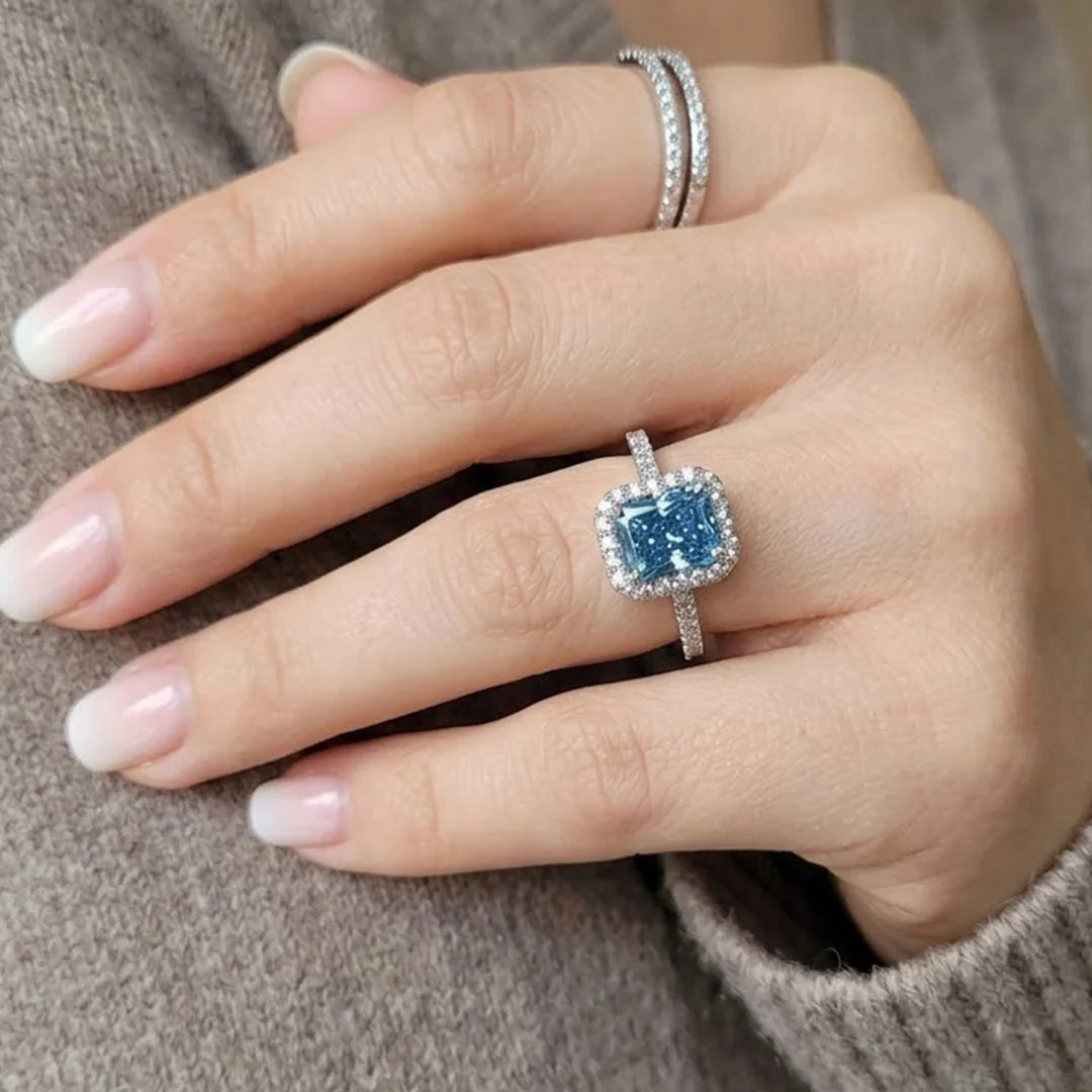 Emerald cut blue sapphire engagement ring close up