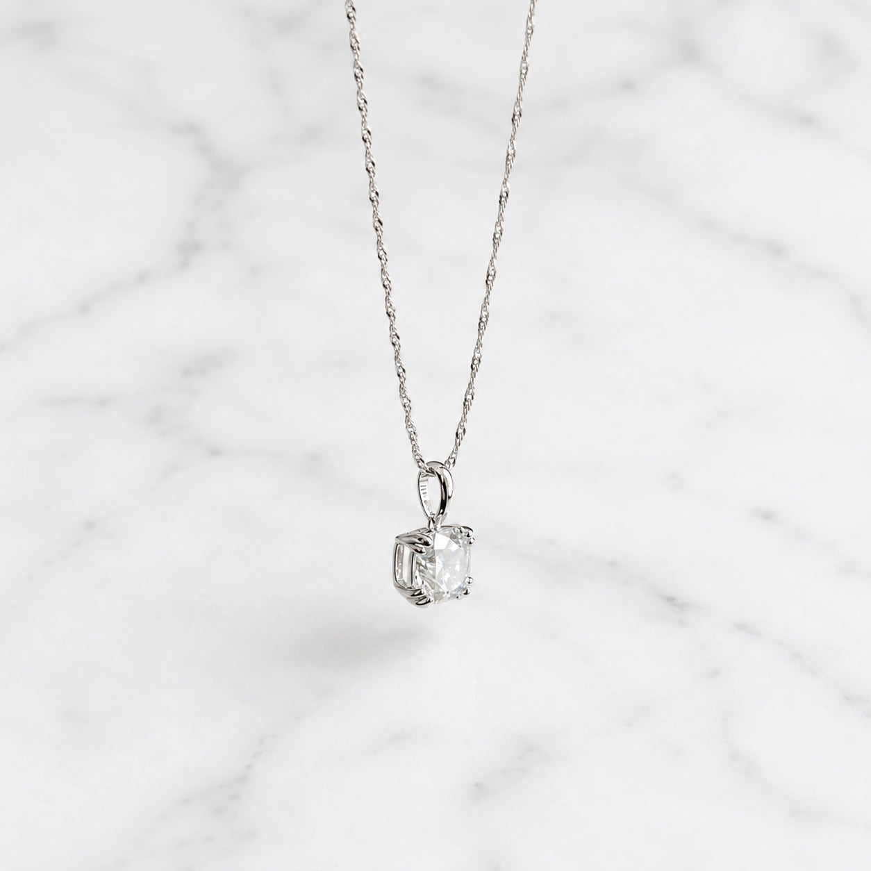 Woman wearing 3 ct cushion cut moissanite pendant necklace in 18k yellow gold