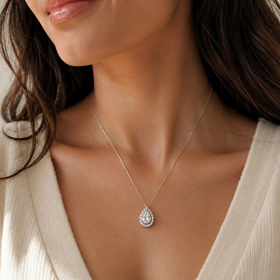 Model shot showing 14k gold halo pear cut moissanite necklace drape on neck